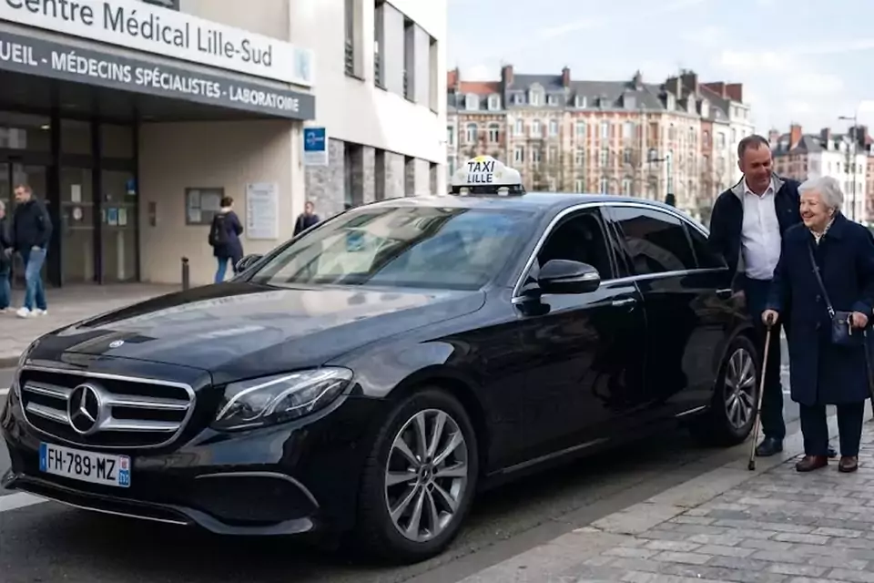 Taxi Lille Annezin : chauffeur de taxi aidant une passagère devant un centre médical