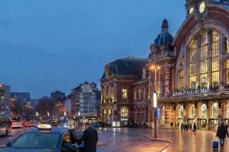 Taxi Lille Auchy-les-Mines : taxi noir stationné devant une gare en soirée