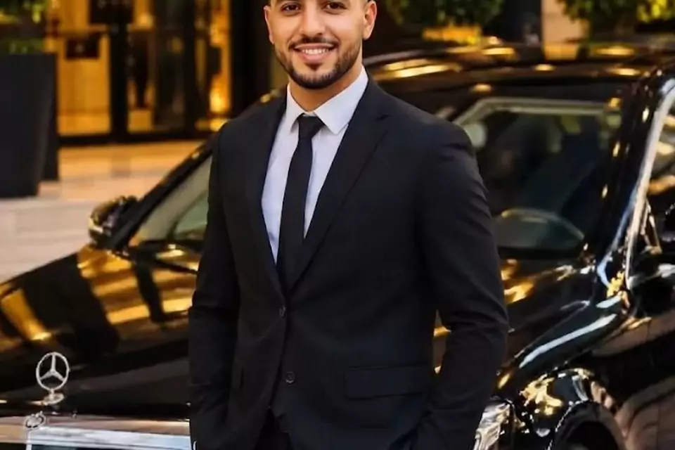 Taxi Lille Avesnes-sur-Helpe : chauffeur de taxi souriant devant sa berline noire