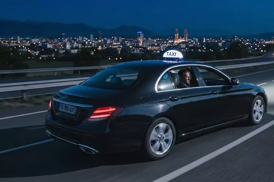 Taxi Lille Bailleul : taxi noir en trajet de nuit avec la ville en arrière-plan