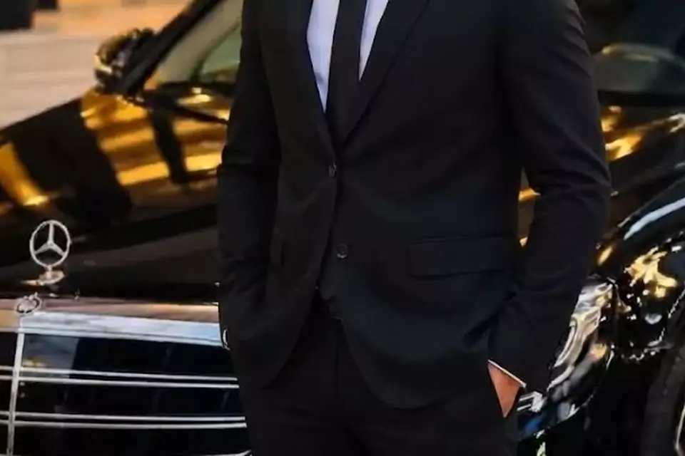 Taxi Lille Beaurains : chauffeur de taxi souriant devant sa berline noire