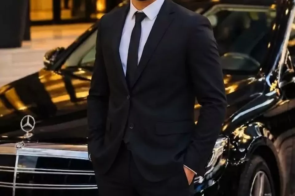 Taxi Lille Bergues : chauffeur de taxi souriant devant sa berline noire