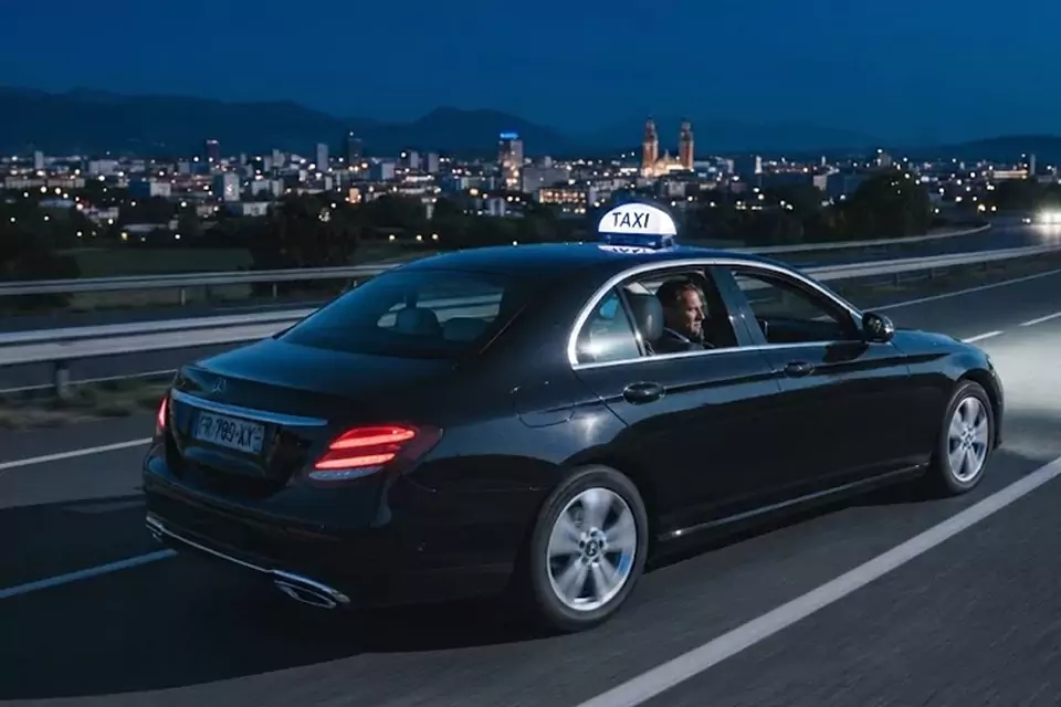Taxi Lille Bouchain : taxi noir en trajet de nuit avec la ville en arrière-plan