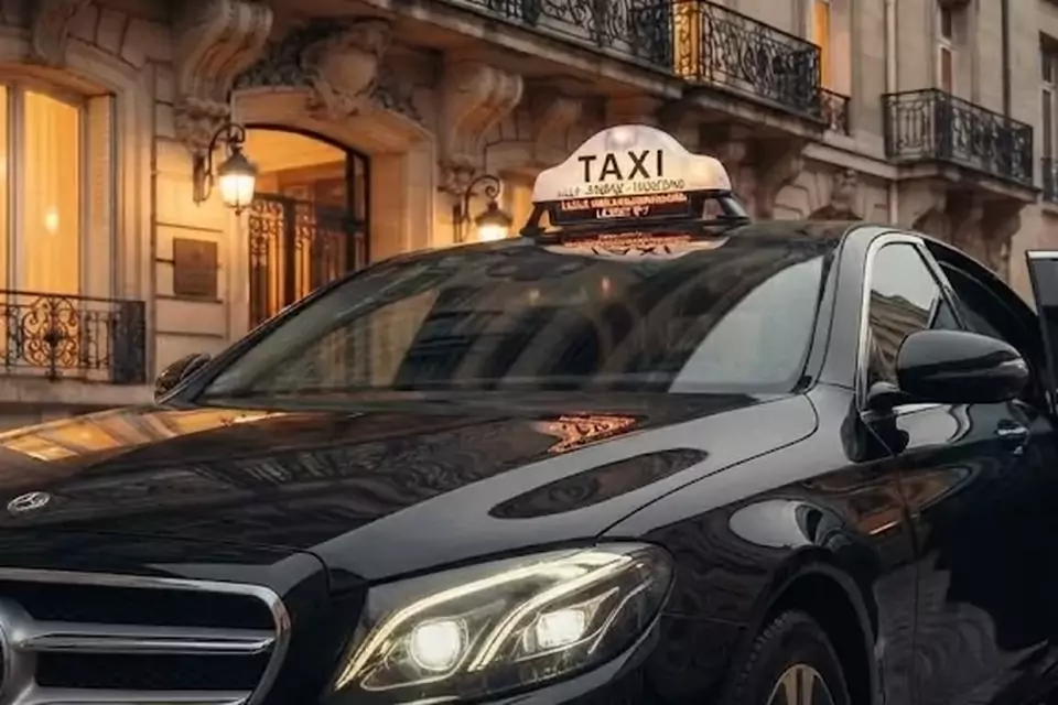 Taxi Lille Bourbourg : berline noire avec enseigne taxi devant une façade éclairée