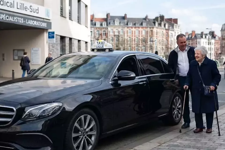 Taxi Lille Bray-Dunes : chauffeur de taxi aidant une passagère devant un centre médical