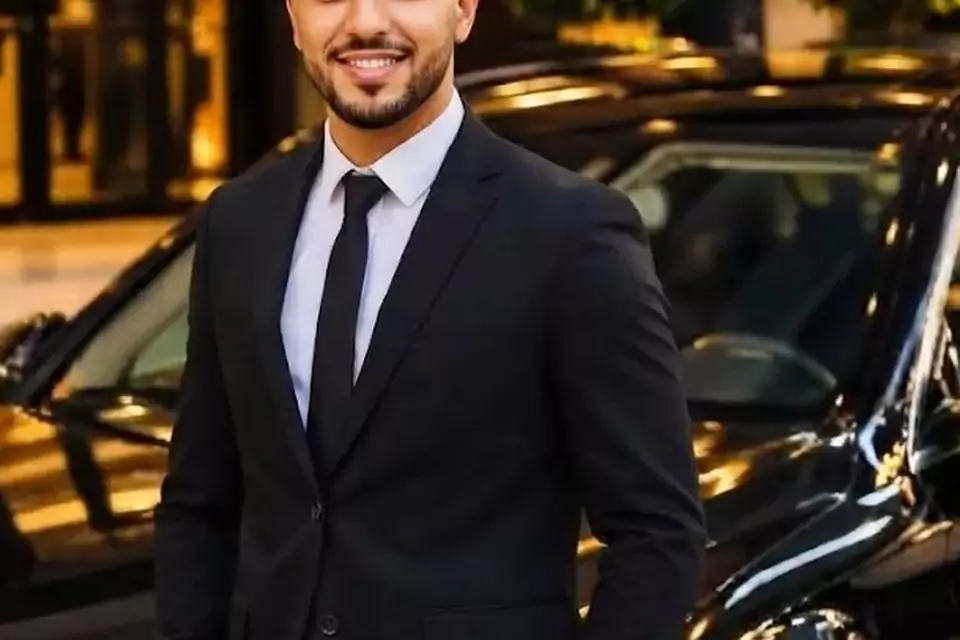 Taxi Lille Carvin : chauffeur de taxi souriant devant sa berline noire
