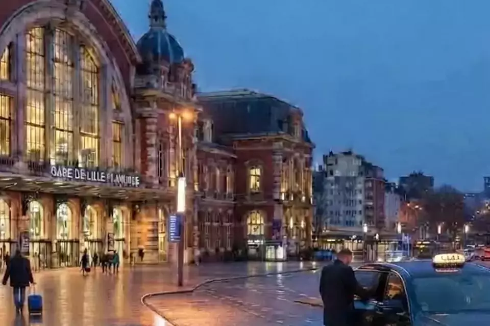 Taxi Lille Coulogne : taxi noir stationné devant une gare en soirée