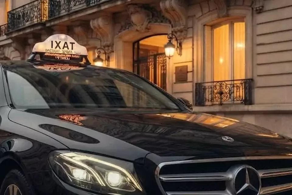 Taxi Lille Cucq : berline noire avec enseigne taxi devant une façade éclairée