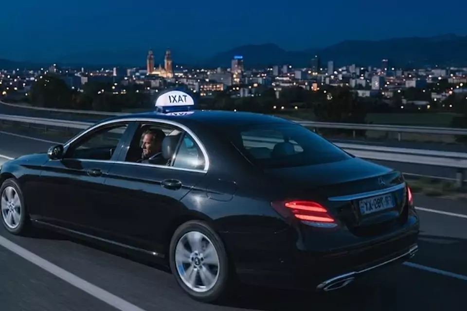 Taxi Lille Dainville : taxi noir en trajet de nuit avec la ville en arrière-plan