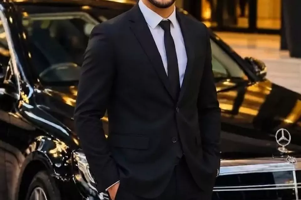 Taxi Lille Denain : chauffeur de taxi souriant devant sa berline noire