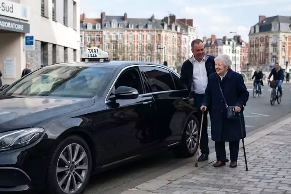 Taxi Lille Desvres : chauffeur de taxi aidant une passagère devant un centre médical