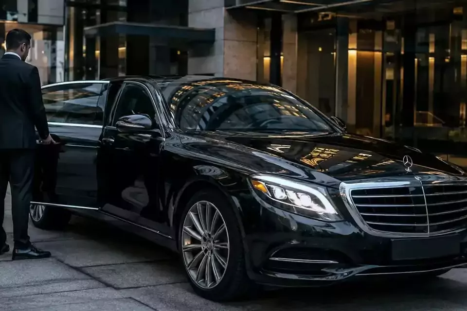 Taxi Lille Fouquières-lès-Lens : chauffeur ouvrant la portière d’une berline noire devant un hôtel