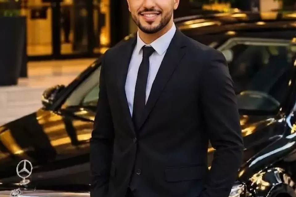Taxi Lille Grenay : chauffeur de taxi souriant devant sa berline noire