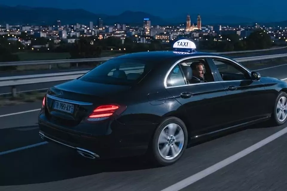 Taxi Lille Halluin : taxi noir en trajet de nuit avec la ville en arrière-plan