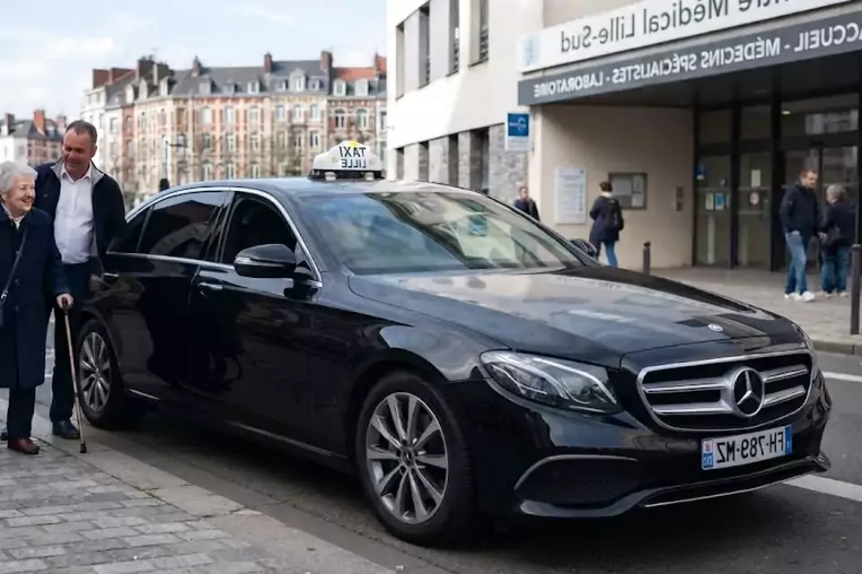 Taxi Lille Hesdin : chauffeur de taxi aidant une passagère devant un centre médical