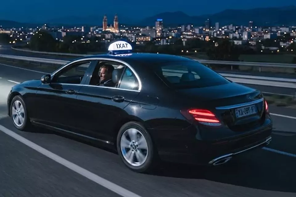 Taxi Lille Leffrinckoucke : taxi noir en trajet de nuit avec la ville en arrière-plan