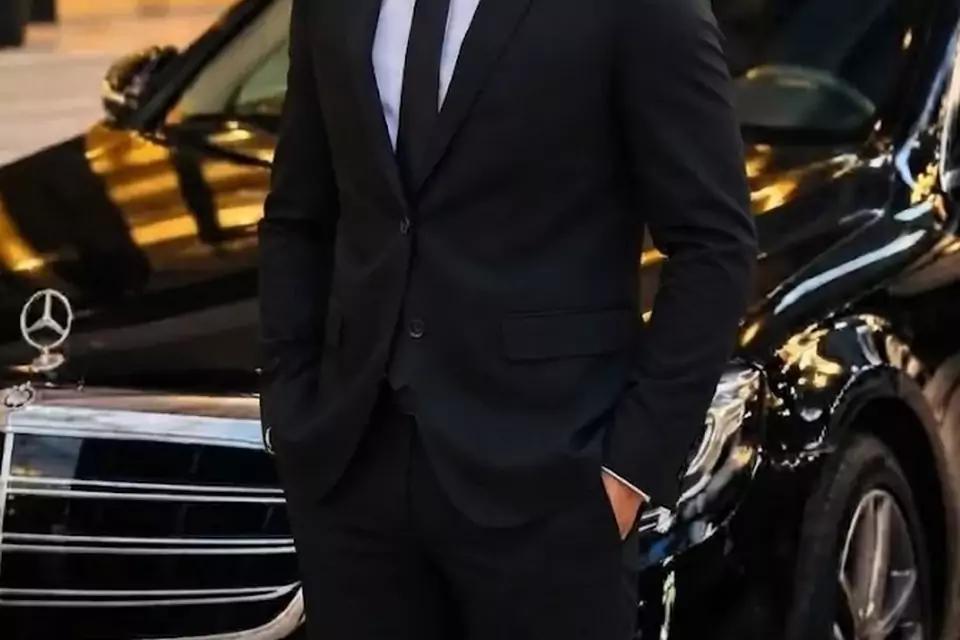 Taxi Lille Leforest : chauffeur de taxi souriant devant sa berline noire