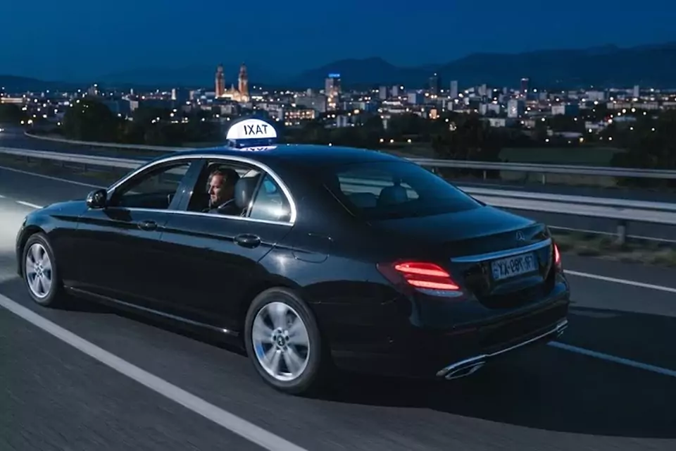 Taxi Lille Lillers : taxi noir en trajet de nuit avec la ville en arrière-plan