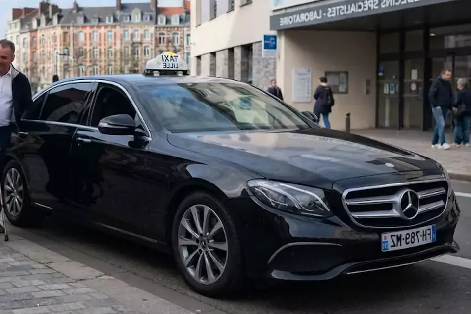 Taxi Lille Marck : chauffeur de taxi aidant une passagère devant un centre médical