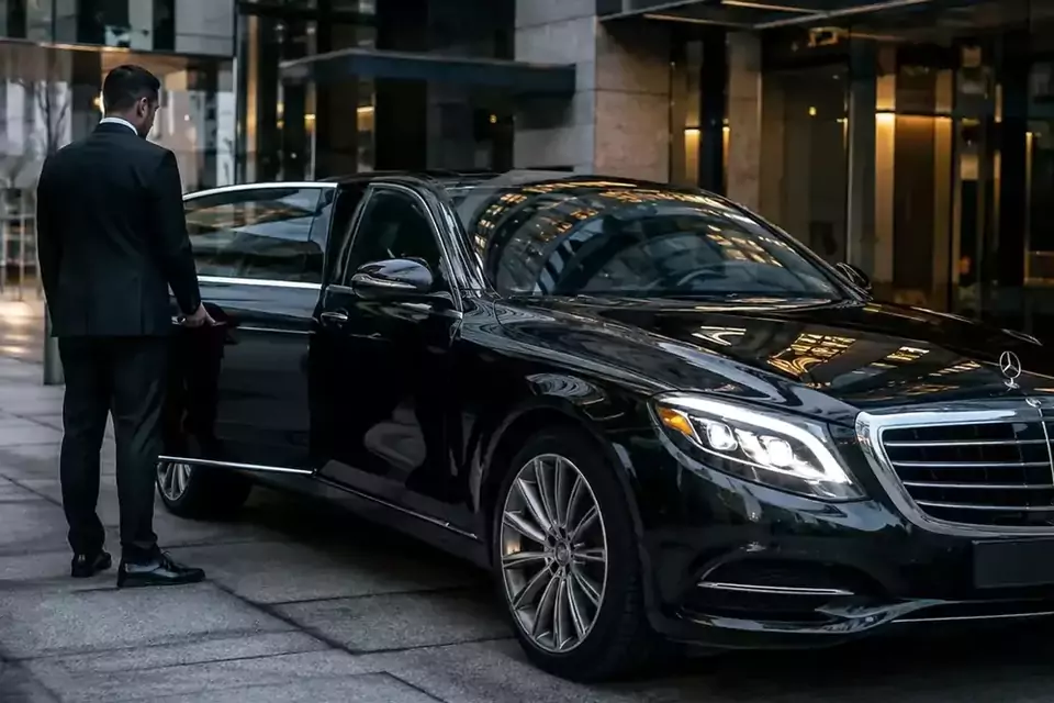 Taxi Lille Marquise : chauffeur ouvrant la portière d’une berline noire devant un hôtel
