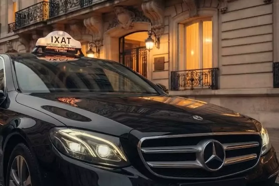 Taxi Lille Onnaing : berline noire avec enseigne taxi devant une façade éclairée