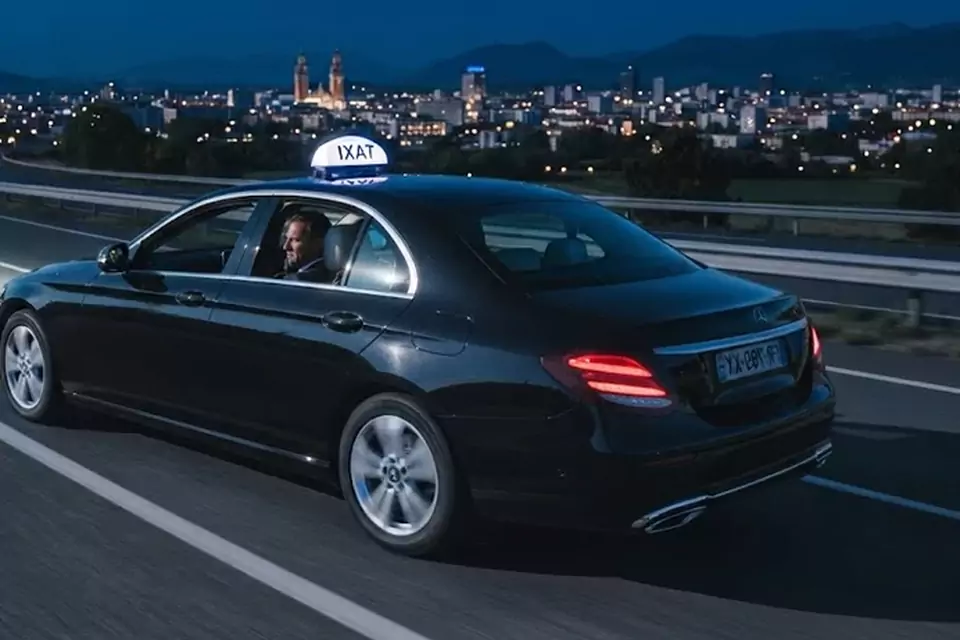Taxi Lille Raismes : taxi noir en trajet de nuit avec la ville en arrière-plan