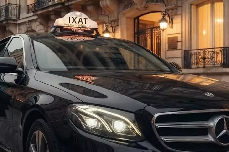 Taxi Lille Rouvroy : berline noire avec enseigne taxi devant une façade éclairée