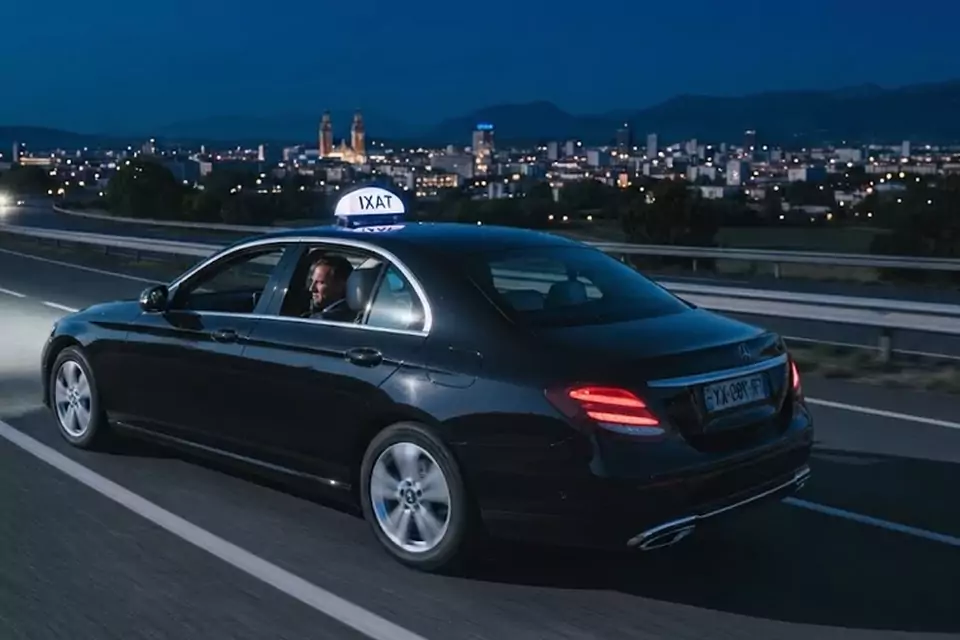 Taxi Lille Sailly-sur-la-Lys : taxi noir en trajet de nuit avec la ville en arrière-plan