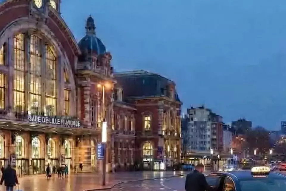 Taxi Lille Sains-en-Gohelle : taxi noir stationné devant une gare en soirée