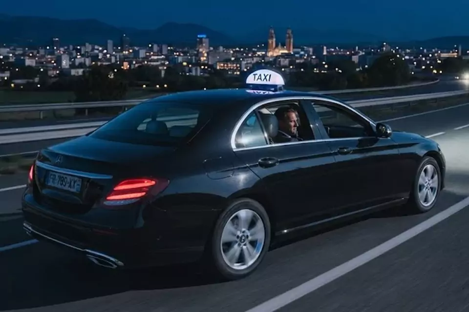 Taxi Lille Saint-Pol-sur-Ternoise : taxi noir en trajet de nuit avec la ville en arrière-plan