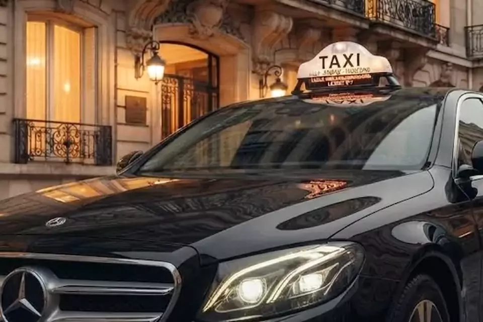 Taxi Lille Vieux-Condé : berline noire avec enseigne taxi devant une façade éclairée