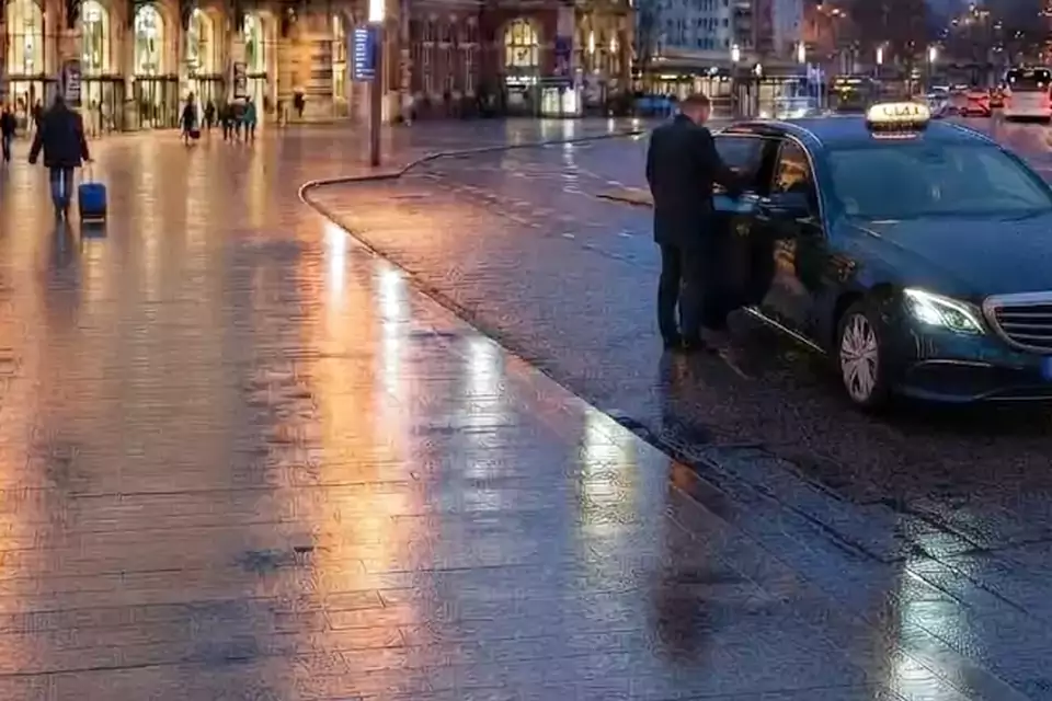 Taxi Lille Wimille : taxi noir stationné devant une gare en soirée